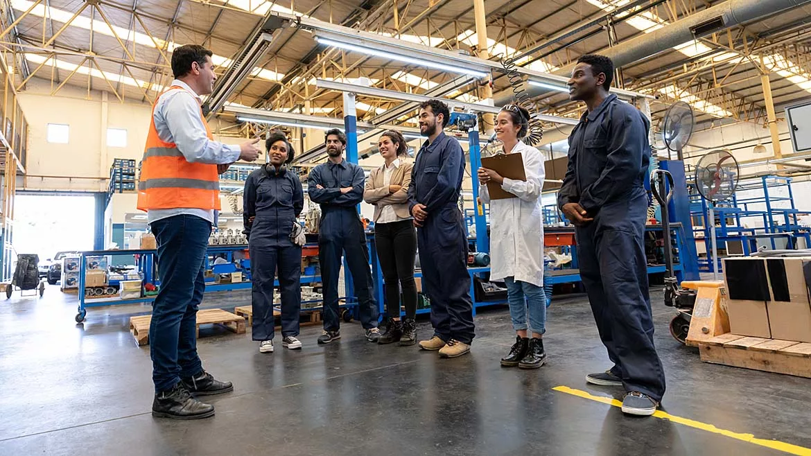 a factory floor during what appears to be a training session or a daily briefing