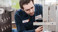 an employee working with injection molding tooling in a manufacturing setting