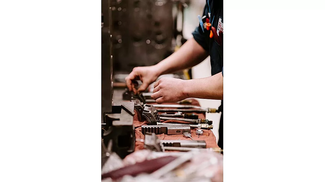 a worker arranging tools on a workbench alongside a blue exchange icon