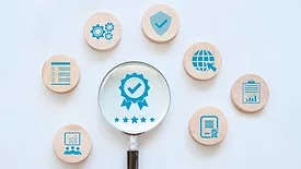various icons on wooden discs representing quality assurance and ISO standards