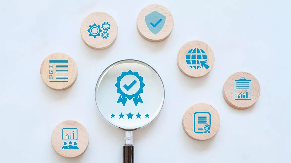 various icons on wooden discs representing quality assurance and ISO standards