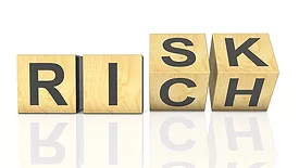 wooden cubes arranged to spell "Risk" and "Rich"