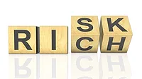wooden cubes arranged to spell "Risk" and "Rich" wooden cubes arranged to spell "Risk" and "Rich"