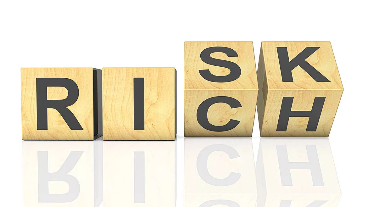 wooden cubes arranged to spell "Risk" and "Rich"