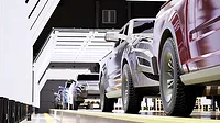 This image depicts a modern automotive manufacturing assembly line, likely focusing on quality control inspections for new pickup trucks This image depicts a modern automotive manufacturing assembly line, likely focusing on quality control inspections for new pickup trucks