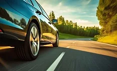 Passenger vehicle driving on a paved road, representing automotive performance, durability testing, and real-world driving conditions.