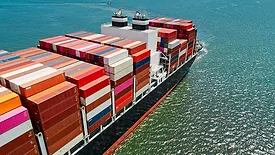 a massive container ship loaded with cargo containers traversing open water.