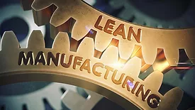 Close-up of gold gears with "Lean Manufacturing" etched on them.