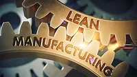 Close-up of gold gears with "Lean Manufacturing" etched on them.