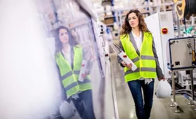 woman in reflective vest carrying binder